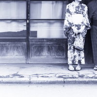 古い建物の前に立つ和装男女のポートレートの写真