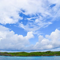 孤島のような入り江の沖縄の海と透明な海水の写真