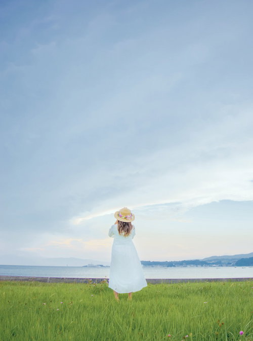 麦わら帽子をかぶり海岸を眺める透明感女子