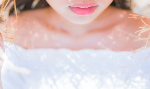 麦わら帽子の影が落ちた女性の口元とリップメイク