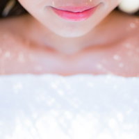 麦わら帽子の影からそっと微笑む口元とピンク色の唇の写真