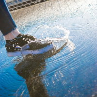 水たまりを踏んで跳ね上がる水しぶきの写真