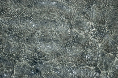 砂浜に寄せる波が作る砂と水面のテクスチャ