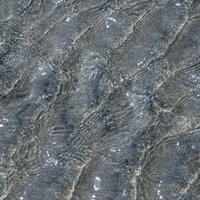 水面に映る波のテクスチャ、岩肌の風化による縞模様の写真