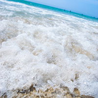 晴れた日の砂浜と海の波打ち際の写真