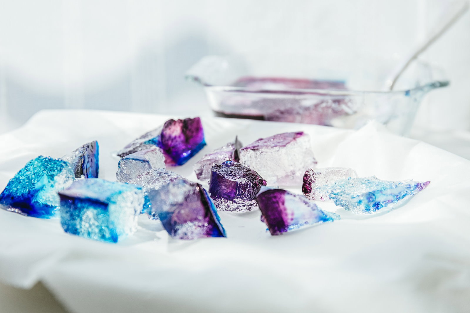 白い容器に盛られた青や紫色の透明な琥珀糖