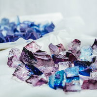 紫とブルーに輝く琥珀糖、白い布に散りばめられた宝石のようなお菓子の写真