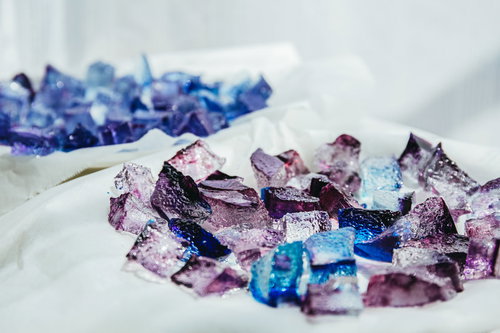 紫とブルーに輝く琥珀糖、白い布に散りばめられた宝石のようなお菓子