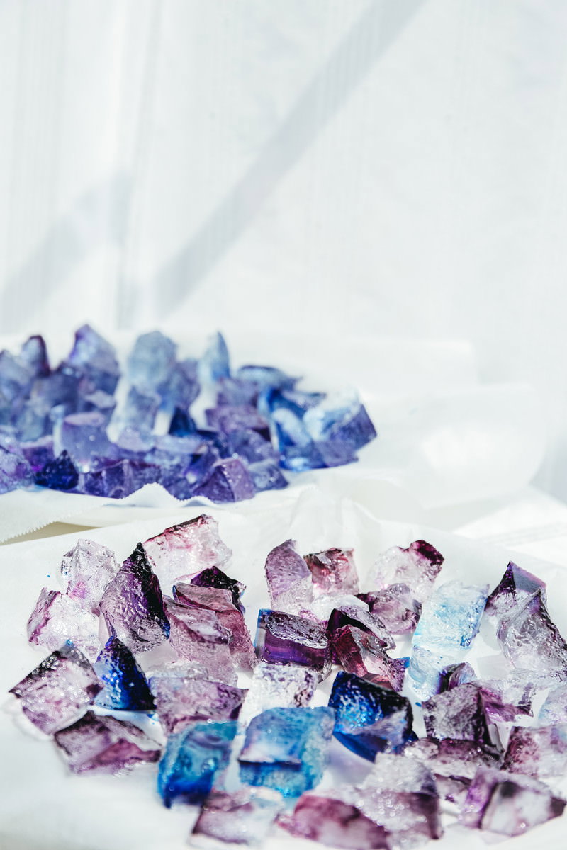 キラキラと輝くカラフルな琥珀糖が白い背景に配置されている