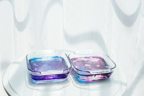 固まるのを待つ紫とピンクの琥珀糖、寒天を使った透明な宝石菓子