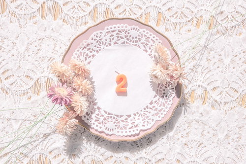 アンティークな淡いピンク色のお皿と白い数字の「2」