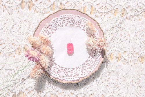 レース模様のクロスに置かれたアンティークなお皿と数字の9