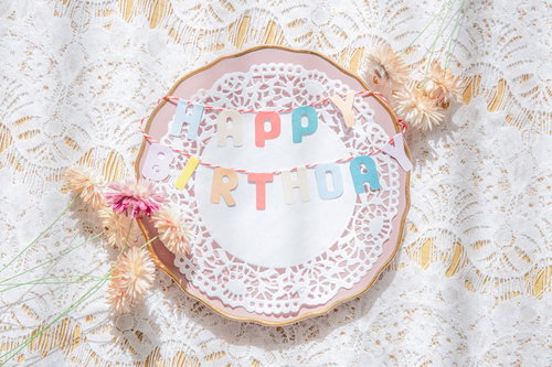 ハッピーバースデイ！白い皿に飾られたケーキとデコレーション