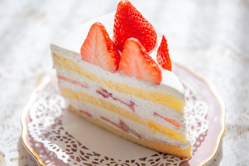 白い生クリームと鮮やかな赤い苺がトッピングされたショートケーキ