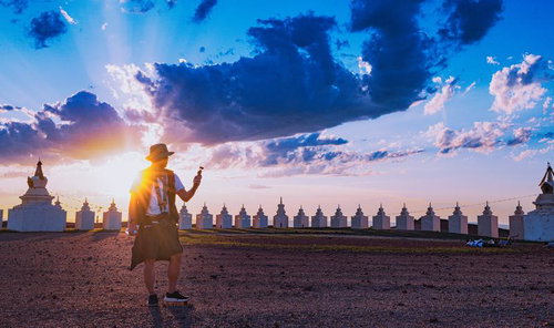 モンゴルの世界エネルギーセンターで夕焼けに照らされる旅人