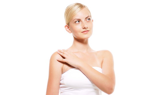 右肩の張りを確認している外国人の金髪女性