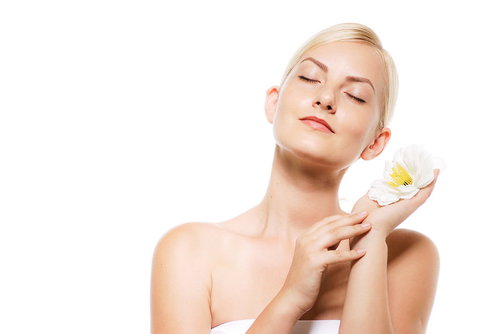 目を閉じて顔に寄せた花の香りを楽しむロシア人女性モデル