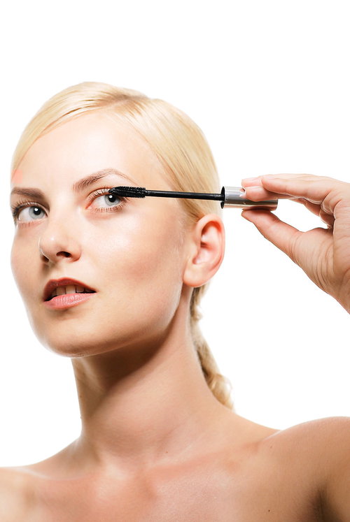 白背景でマスカラをつける金髪の外国人女性