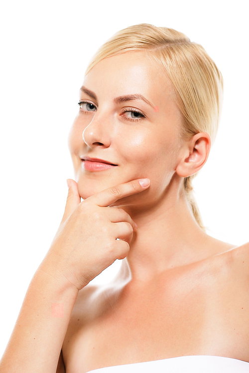 顎に手を当てて微笑む金髪の外国人美容女性