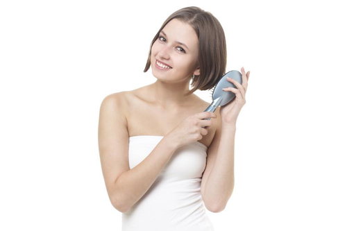 ヘアケア製品を手にした笑顔の女性のポートレート