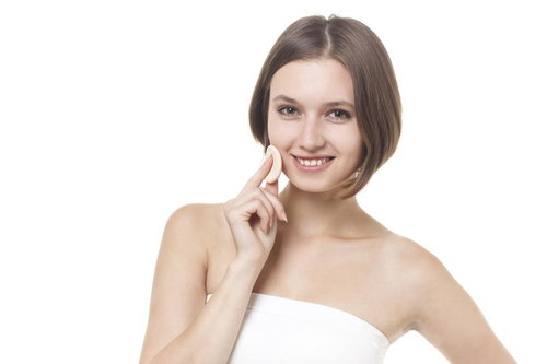 パフでスキンケアしながら微笑むショートボブの女性