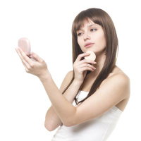 パフで化粧直しをする女性の写真