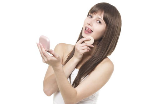 パフで化粧直しをする女性
