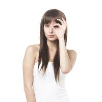 OKサインを目元にかざす女性の写真