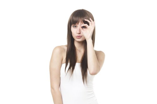 OKサインを目元にかざす女性の写真