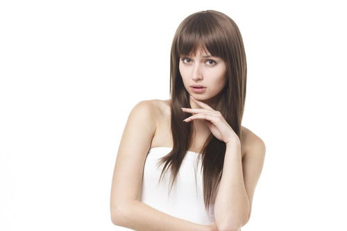 あごに手を添えるロングヘアのロシア人女性の写真