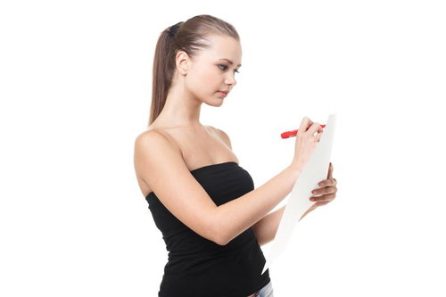 白い用紙にペンで書き込みをする女性