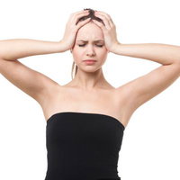 頭を抱えて悩む女性の写真