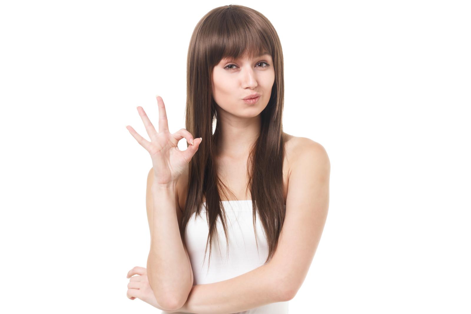 A woman model in white clothing making an OK sign against a white background