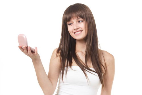 メイク用品を手に取る笑顔の女性モデル