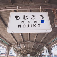 門司港駅のホームに掲げられた駅名標、木造駅舎の歴史的建築の写真