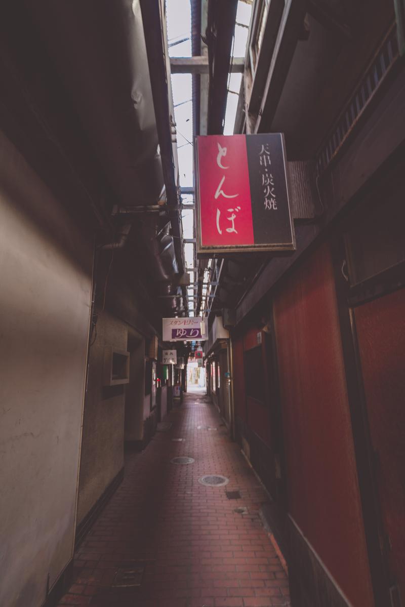 門司港レトロの路地裏に赤い看板がある飲食店の通路