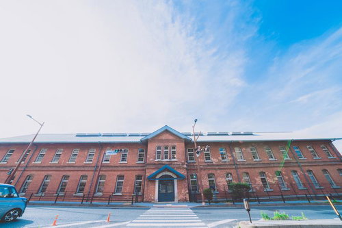 門司港の横断歩道の先にある赤レンガ建物と青空