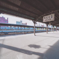 門司港駅のホームから眺める青い列車と駅舎の写真