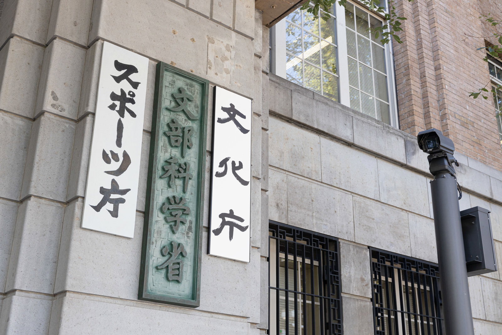 白い建物の壁に設置されたスポーツ庁と文部科学省と文化庁の緑色の銘板