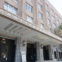 文部科学省の正面出入口、白い建物のガラス張りエントランスの写真