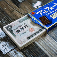 一万円札と洋菓子で表現するフォート貯金なうの写真