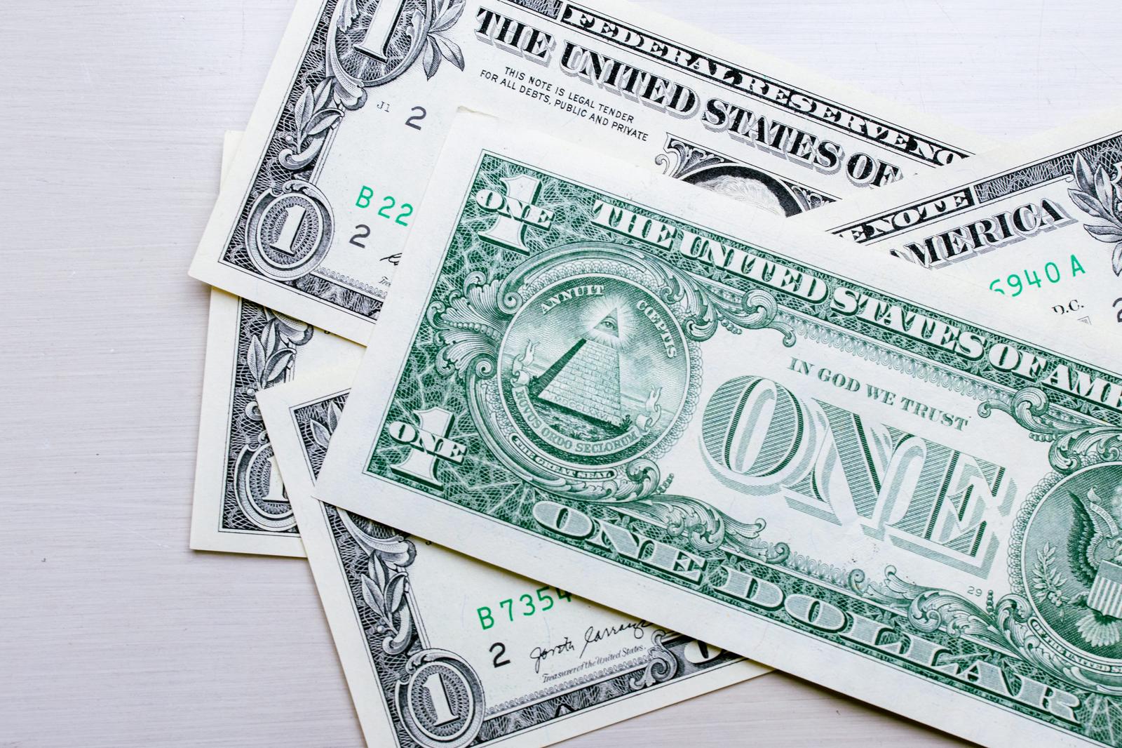 複数枚の1ドル紙幣が重なり、裏面のピラミッドと緑色の印刷が見える
