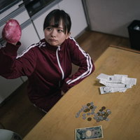失業して貧困に陥った女性がワンルームで座り込むの写真