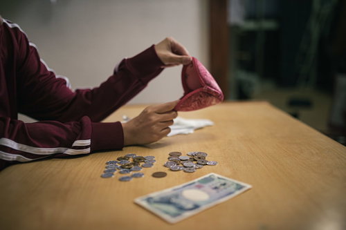 今月の生活費はこれで全部、テーブルに散らばる小銭と千円札