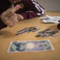 生活費がピンチで小銭を数える女性の家計管理の写真