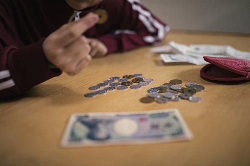 生活費がピンチで小銭を数える女性の家計管理