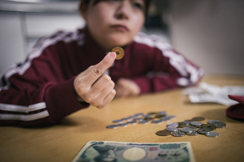 ご縁がありますように、五円玉を持つ女性の手元