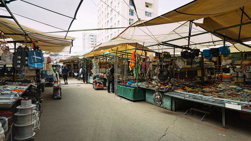 黄色いテント屋根の下に工具や雑貨が並ぶモンゴルの市場通路