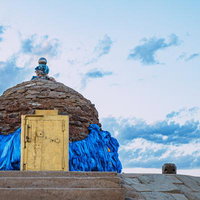 モンゴルの世界エネルギーセンターで聖なる布を背にカメラを構える旅人の写真