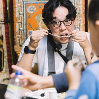 遊牧民から提供された羊肉を食べるYouTuber男性の写真